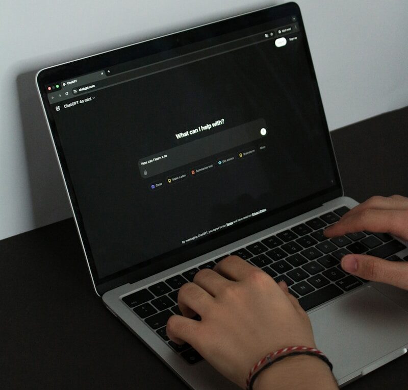 A person typing on a laptop on a table